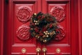 Red front door with Christmas wreath and street festive decorations on holidays Royalty Free Stock Photo