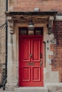 Red front door of a traditional Englsih house on a street in Oxford, UK