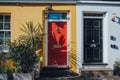 Red front door on a yellow house in London, UK