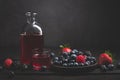 Red fruit detox juice with berries on dark background