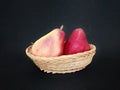 Red fruit pear on bamboo basket on black background