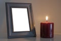 Red funeral candle next to a blank wood photo frame Royalty Free Stock Photo