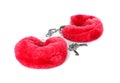 Red furry handcuffs on white background. Accessory for sexual roleplay