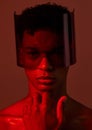 Red future night, black man portrait and futuristic punk glasses on face against dark background in studio. Cyber model