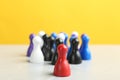 Red game piece near group of others on table, closeup. Career promotion concept Royalty Free Stock Photo