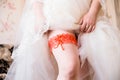 Red garter on leg of the bride, morning bride, the bride wears a Royalty Free Stock Photo