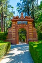 Red gate at gardens of Real Alcazar de Sevilla in Spain Royalty Free Stock Photo