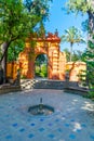 Red gate at gardens of Real Alcazar de Sevilla in Spain Royalty Free Stock Photo