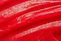 Red gel texture. Cosmetic clear liquid cream smudge. Skin care product sample closeup. Toothpaste or wax