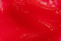 Red gel texture. Cosmetic clear liquid cream smudge. Skin care product sample closeup. Toothpaste or wax