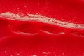 Red gel texture. Cosmetic clear liquid cream smudge. Skin care product sample closeup. Toothpaste or wax