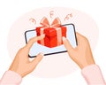 Red gift box with a bow in a mobile phone in hands. The concept of virtual congratulations. Festive background