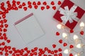 Red gift box , bright white heart-shaped garlands on a white background. Royalty Free Stock Photo