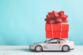Red gift box on car toy with blue pastel color background, retro Royalty Free Stock Photo