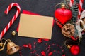 Red gift box with a Christmas toy in the shape of a heart, a golden bell , fir branches, christmas candy, garland and card for Royalty Free Stock Photo