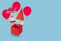 Red gift box with cupcake and colorful party items on blue background Royalty Free Stock Photo