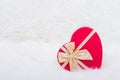 Red gift box in form of heart with beige bow on white furry back Royalty Free Stock Photo