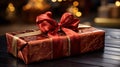 A red gift box with a gold ribbon on rustic wood