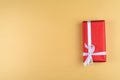 Red gift box on golden background, copy space. Holiday greeting card. Mothers day, birthday. Royalty Free Stock Photo