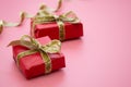 Red gift box and golden bow, on pink background. Valentine's Day, Birthday, Party concept Royalty Free Stock Photo