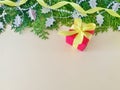 A red gift box with yellow ribbon bow on beige background. Royalty Free Stock Photo