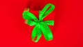 Red gift box with green ribbon and bow on red background. Happy Christmas, New year, Birthday, Valentines day, Womens day Royalty Free Stock Photo