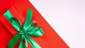 Red gift box with green ribbon and bow on colored background. copy space. Happy Christmas, New year, Birthday, Valentines day, Royalty Free Stock Photo