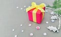 A red gift box on grey background with gemstone and Oriental arborvitae branches.