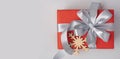 Red gift box with grey ribbon and wooden snowflake on it