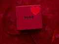 Red gift box is on red heart paper background, top view