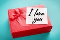 Red gift box with a note with the words I love you on a blue background Royalty Free Stock Photo