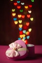 Pink gift box open shaped heart with Defocused bokeh colorful lights heart shaped background