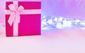 Red gift box with pink ribbon isolated on pink background. Royalty Free Stock Photo