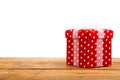 Red gift box, polka dots, on wood background Royalty Free Stock Photo