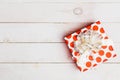 Red gift box with ribbon on white background on white wooden background with copy space, top view. Royalty Free Stock Photo