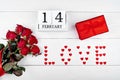 Red gift box, sign Love from hearts, bouquet of res roses and wood block calendar february 14 on white background. Valentines Day Royalty Free Stock Photo