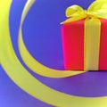 Red Gift box at the end of the spiral yellow ribbon, indigo background, square. Royalty Free Stock Photo