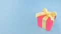 Red gift box with yellow ribbon on blue background . copy space. Royalty Free Stock Photo