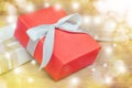 Red gift box white ribbon on wood table with golden bokeh decoration background with copy space. Royalty Free Stock Photo