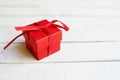 Red gift box on white wooden background with copy space, surprise for birthday, christmas, or valentine`s day Royalty Free Stock Photo