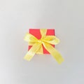 Red gift box with yellow ribbon on beige background. Square. Royalty Free Stock Photo