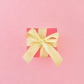 Red gift box with yellow ribbon on pink background. Square. Royalty Free Stock Photo