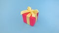 Red gift box with yellow ribbon on blue background. Royalty Free Stock Photo