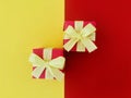 Red gift box with a yellow satin ribbon bow on red and yellow background.es Royalty Free Stock Photo