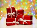 Red gift boxes with ribbon against golden bokeh background, free space. Holiday greeting card for birthday, wedding. Royalty Free Stock Photo