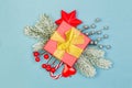 Red gift with gold ribbon and Christmas decorations on blue backgrund