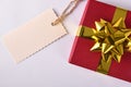 Red gift with golden ribbon and label on the left Royalty Free Stock Photo