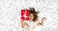 Red Gift. Picture of a little white caucasian girl with curly hair holding red gift box with white ribbon against bright white sil Royalty Free Stock Photo