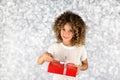 Red Gift. Picture of a little white caucasian girl with curly hair holding red gift box with white ribbon against bright white sil Royalty Free Stock Photo