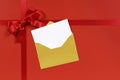 Red gift ribbon bow background with gold envelope and blank invitation or greetings card Royalty Free Stock Photo